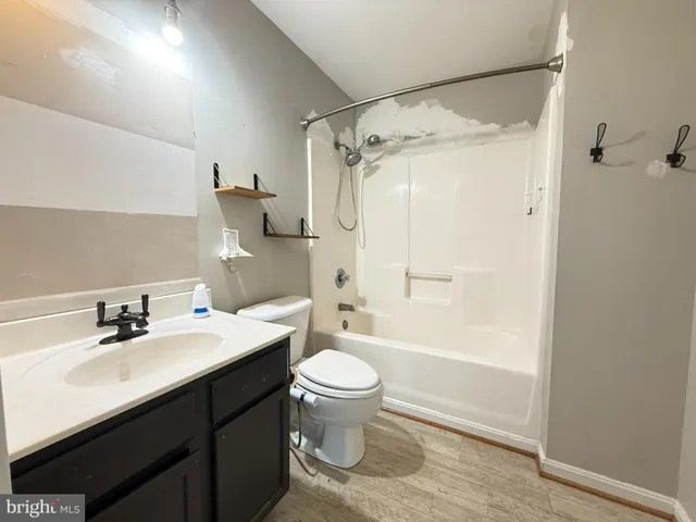 a view of a big room with chandelier fan and windows