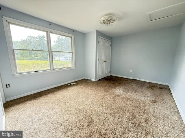 a view of empty room with wooden floor and ceiling fan