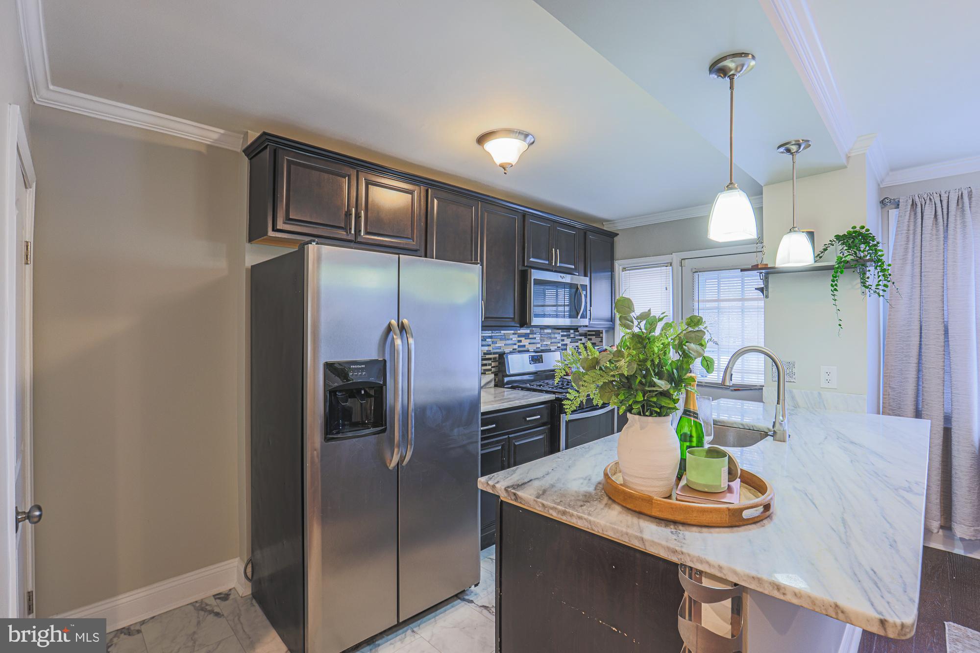 1322 Limit Avenue Baltimore, MD 21239 - Photo 11 of 31 a kitchen with stainless steel appliances granite countertop a refrigerator a stove and a wooden floor
