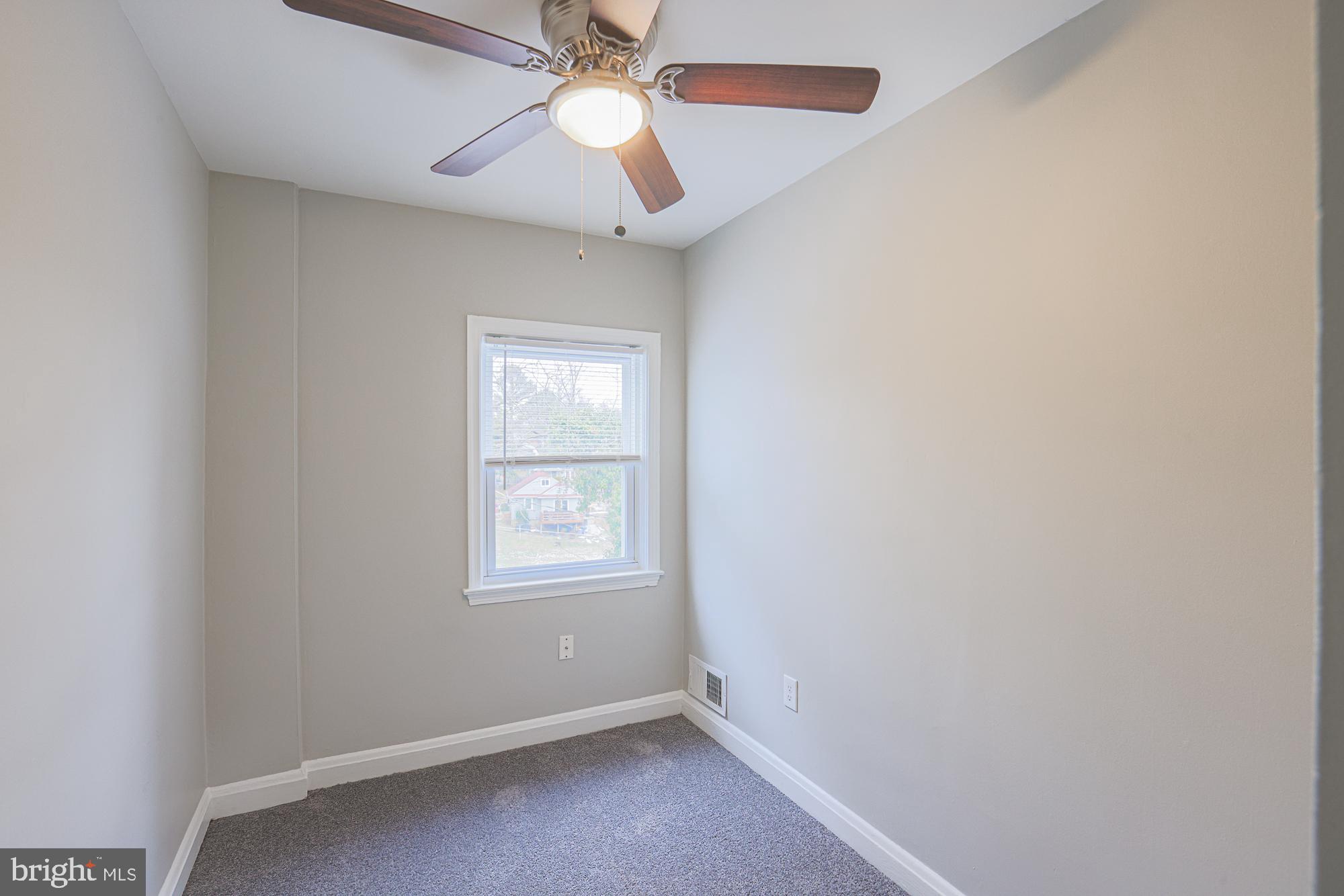 1322 Limit Avenue Baltimore, MD 21239 - Photo 22 of 31 an empty room with windows and fan
