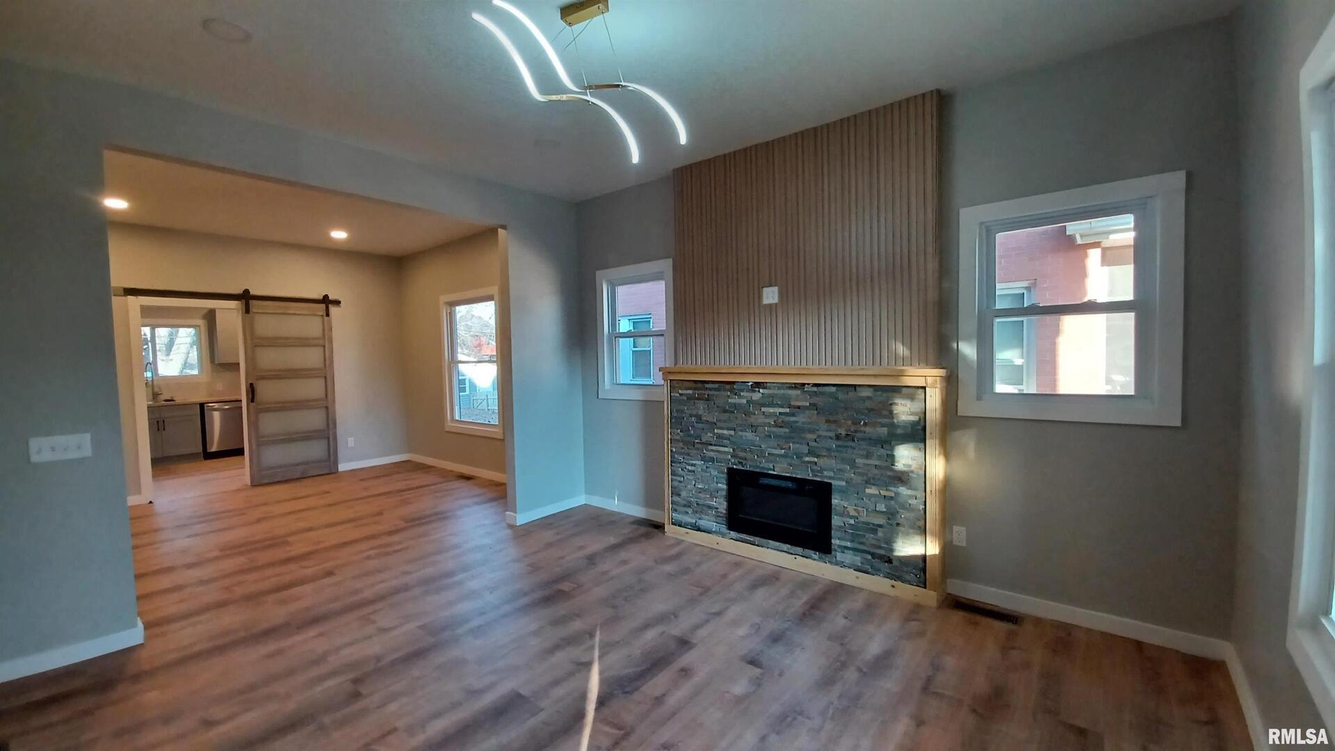 822 6th Avenue South Clinton, IA 52732 - Photo 6 of 28 an empty room with wooden floor fireplace and windows