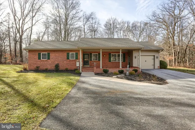 a view of a house with backyard and trees