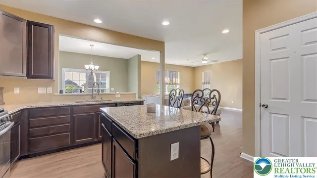 a kitchen with granite countertop kitchen island a sink stove and refrigerator