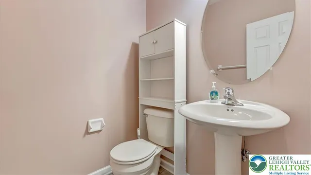 a bathroom with a sink a toilet and mirror