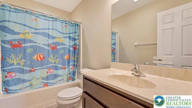 a bathroom with a sink a toilet and a shower curtain