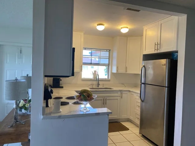 a kitchen with a sink a refrigerator and cabinets