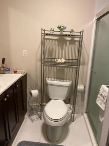 a white toilet sitting next to a sink and vanity