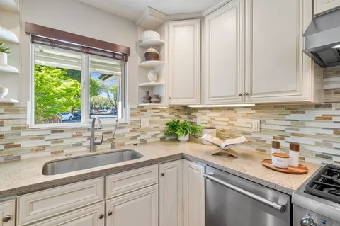 a kitchen with stainless steel appliances a sink a stove and a window
