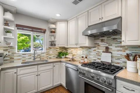 a kitchen with stainless steel appliances granite countertop a refrigerator a stove and a refrigerator