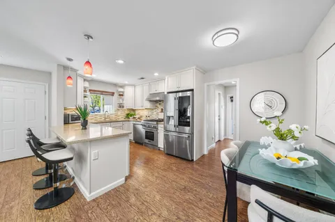 a living room with furniture kitchen and a potted plant