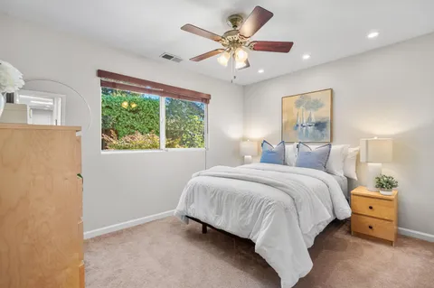 a spacious bedroom with a large bed and a chandelier