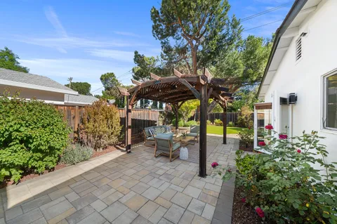 a view of a patio with table and chairs potted plants