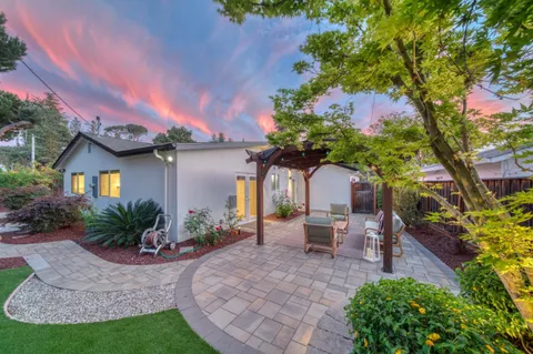 an aerial view of a house with a yard and outdoor seating