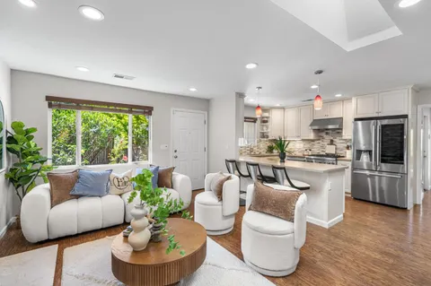 a kitchen with sink stove and living room