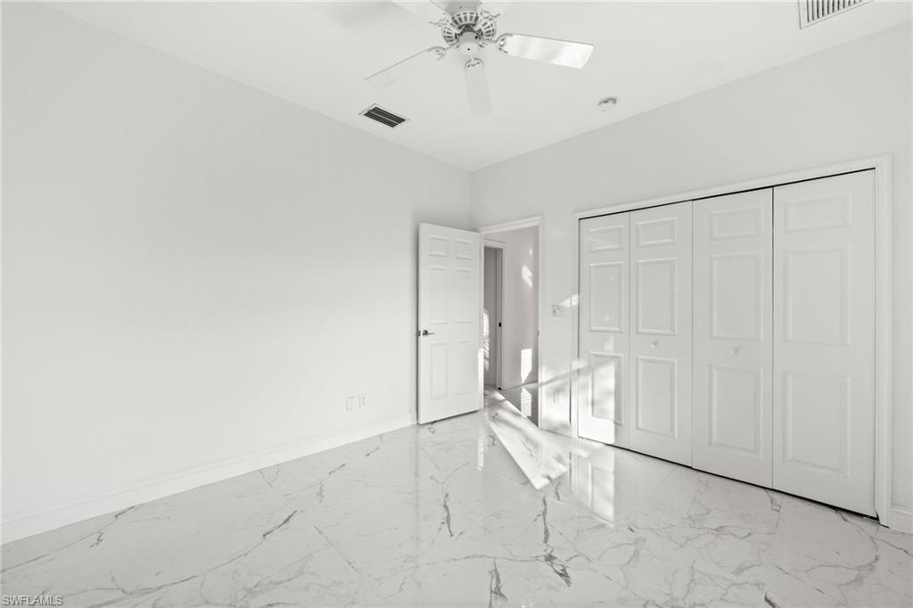 3972 Ruxton Road Naples, FL 34116 - Photo 28 of 41 an empty room with a ceiling fan and glass door