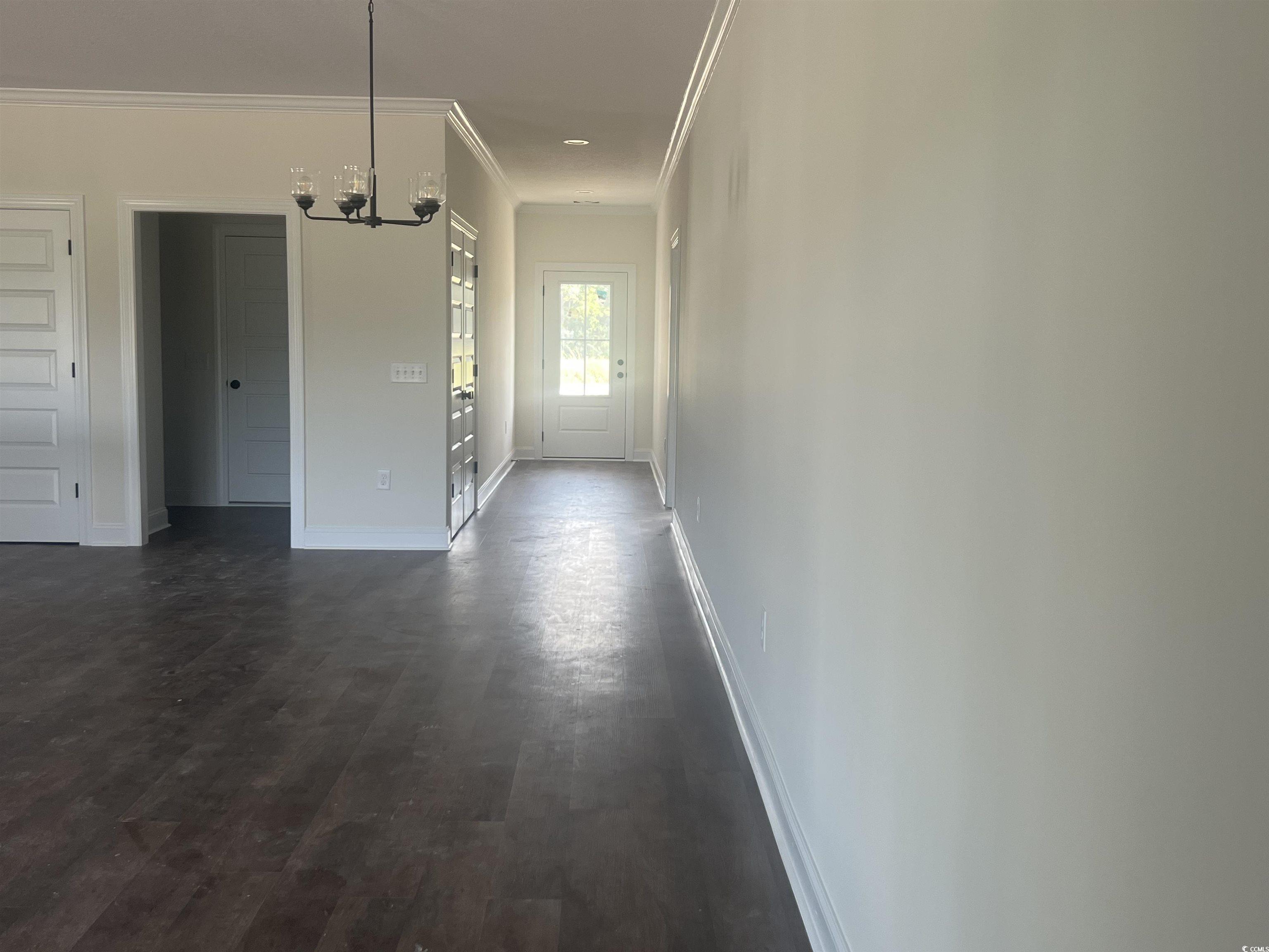 3597 Valley Forge Road Aynor, SC 29511 - Photo 21 of 31 Corridor with crown molding, a chandelier, and dark wood-style flooring