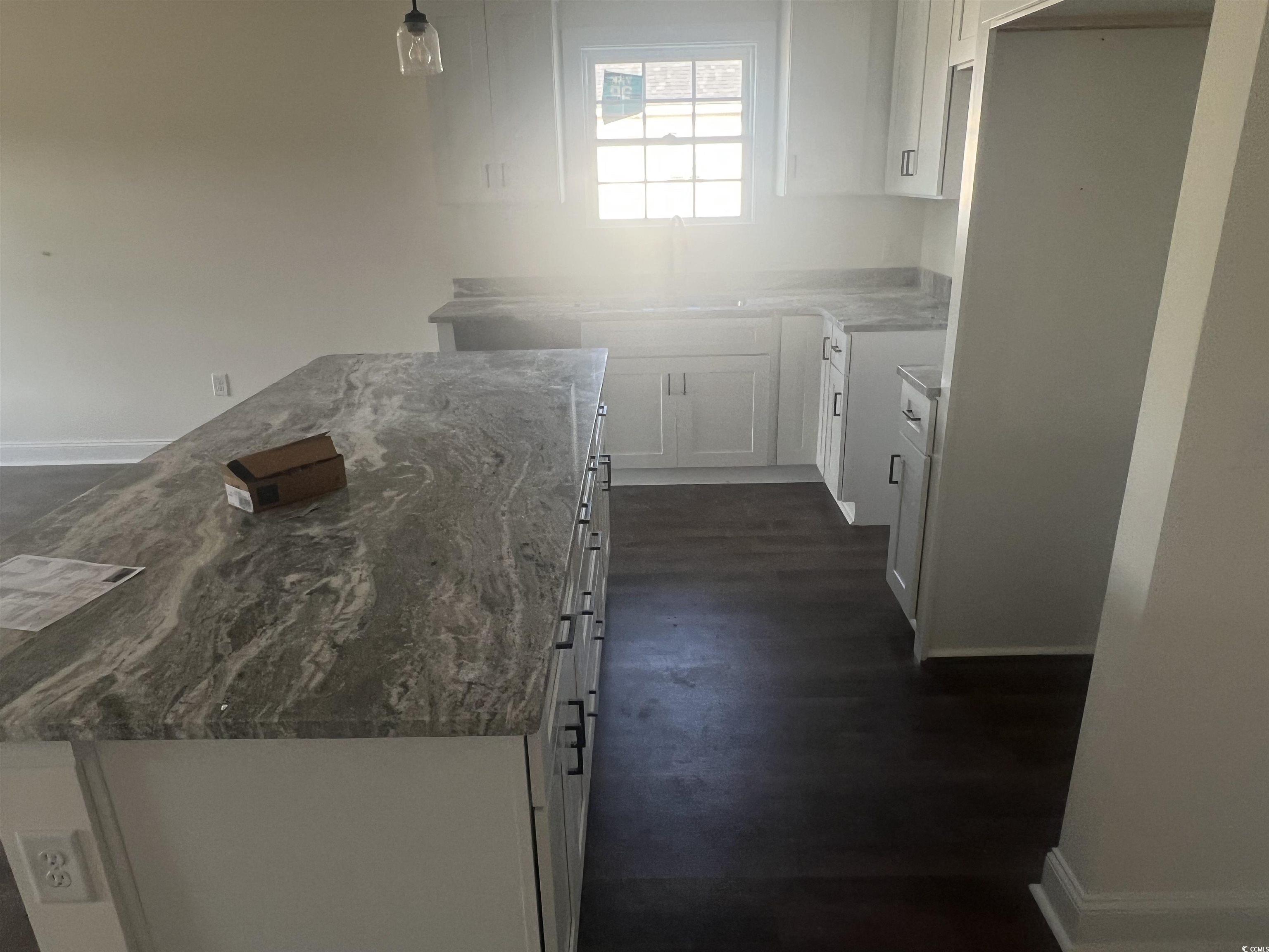 3597 Valley Forge Road Aynor, SC 29511 - Photo 23 of 31 Kitchen featuring white cabinetry, dark stone countertops, decorative light fixtures, and a center island