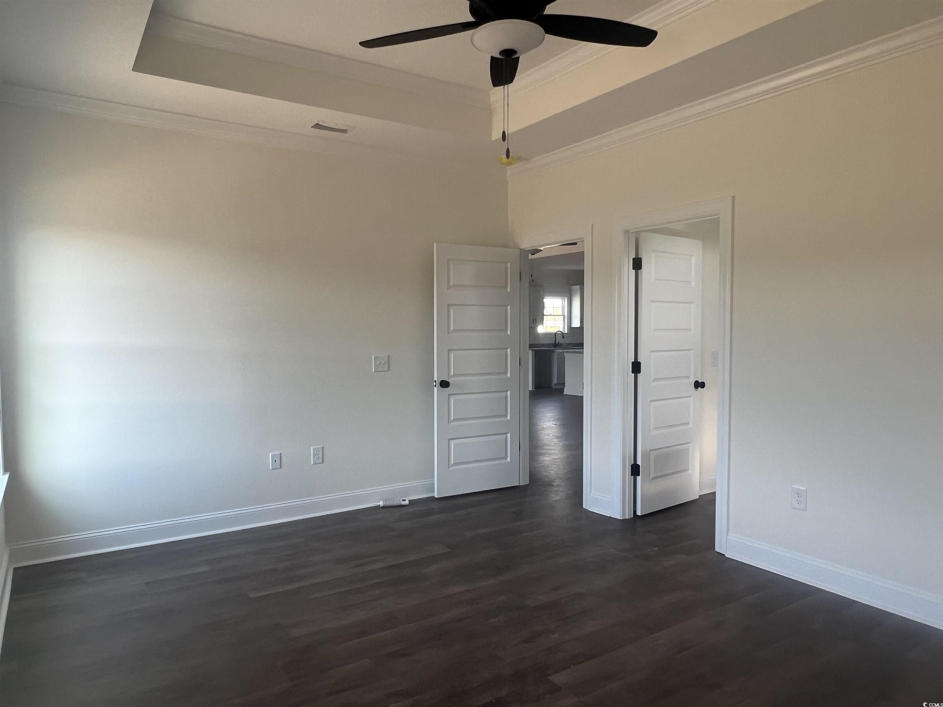3597 Valley Forge Road Aynor, SC 29511 - Photo 26 of 31 Empty room featuring a tray ceiling, dark wood finished floors, crown molding, and a ceiling fan