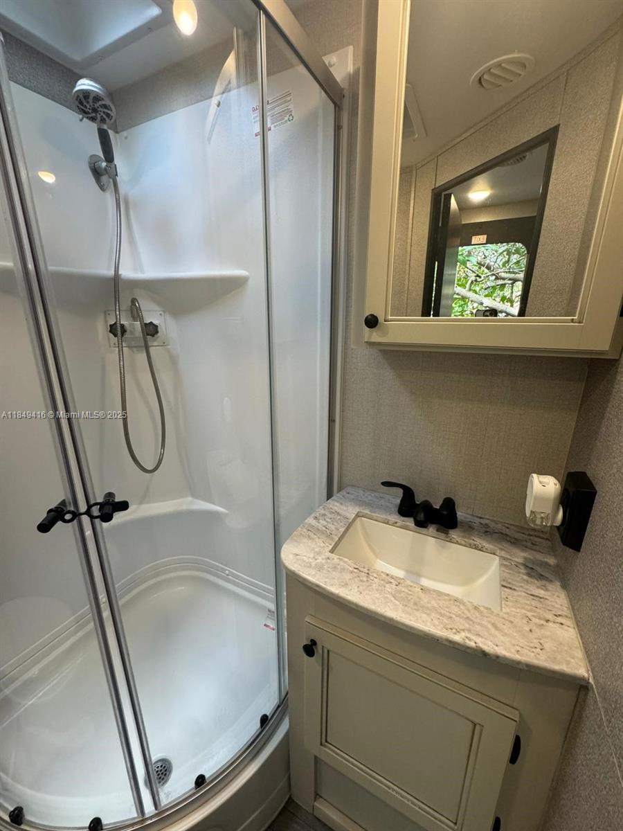 2723 Southwest 13th Street Miami, FL 33135 - Photo 3 of 4 a bathroom with a granite countertop sink a toilet a mirror and shower