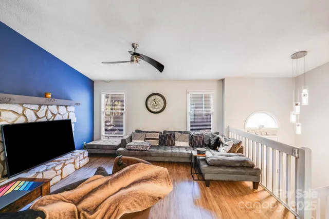 a view of a livingroom with wooden floor and a ceiling fan