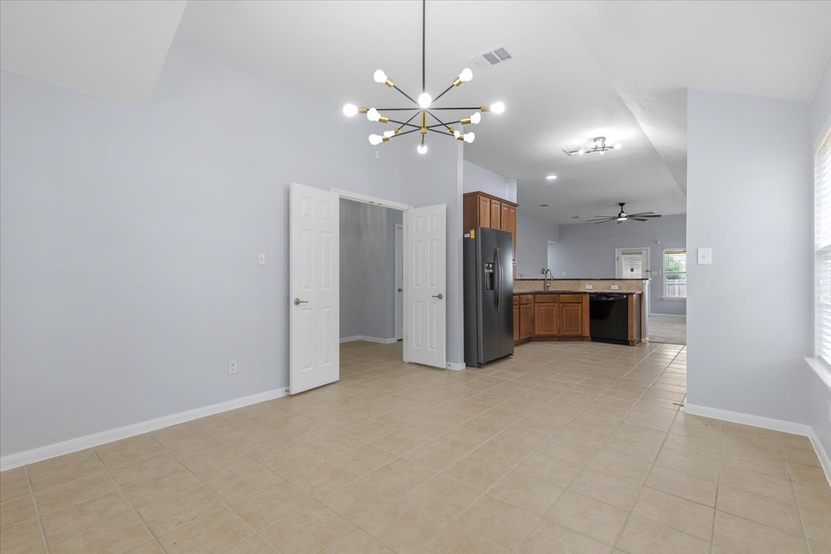 17812 Masi Loop Pflugerville, TX 78660 - Photo 9 of 38 Spacious room featuring tile flooring, vaulted ceilings, and a contemporary chandelier