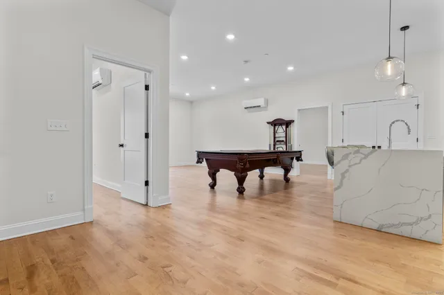 a living room with furniture and a dining table with wooden floor