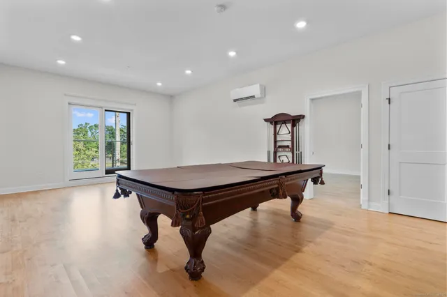 a room with wooden floor and pool table
