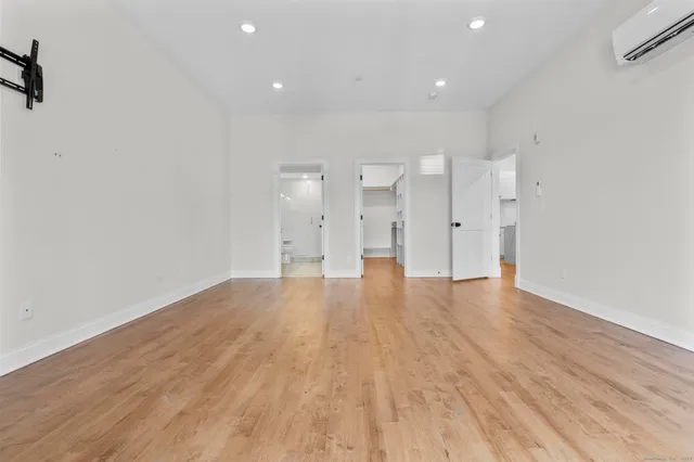 a view of empty room with wooden floor and windows
