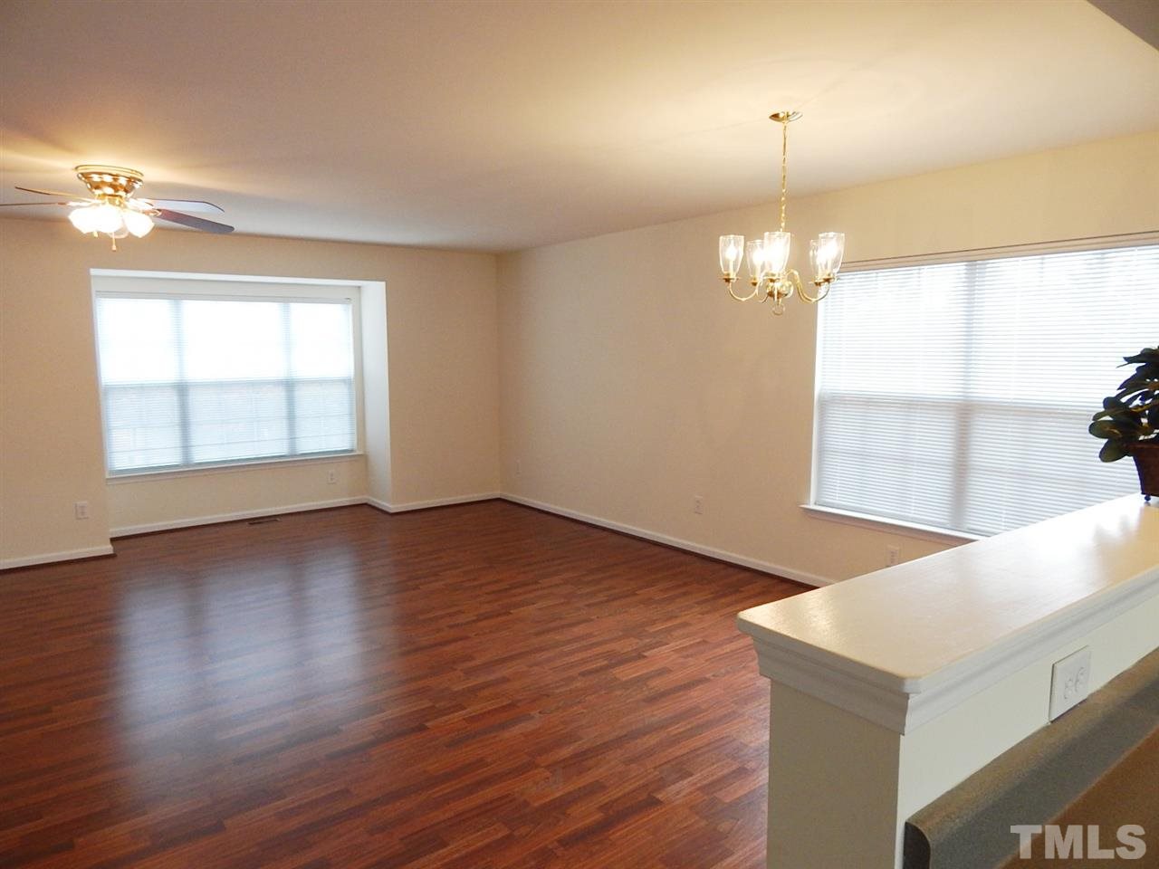 5051 Neuse Commons Lane Raleigh, NC 27616 - Photo 11 of 23 an empty room with wooden floor chandelier and windows