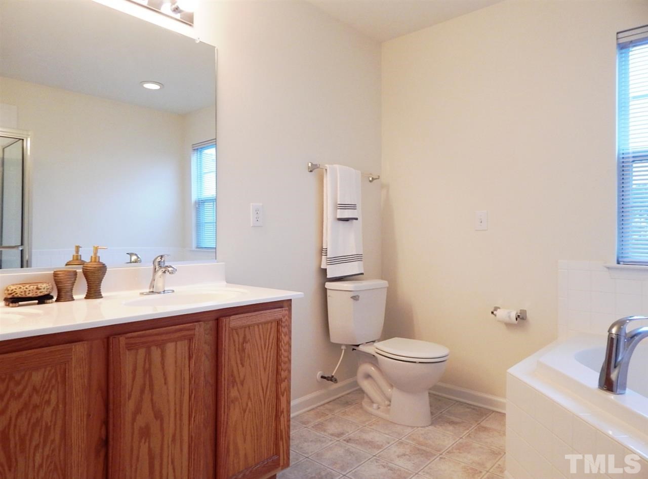 5051 Neuse Commons Lane Raleigh, NC 27616 - Photo 13 of 23 a bathroom with a granite countertop toilet a sink and a mirror