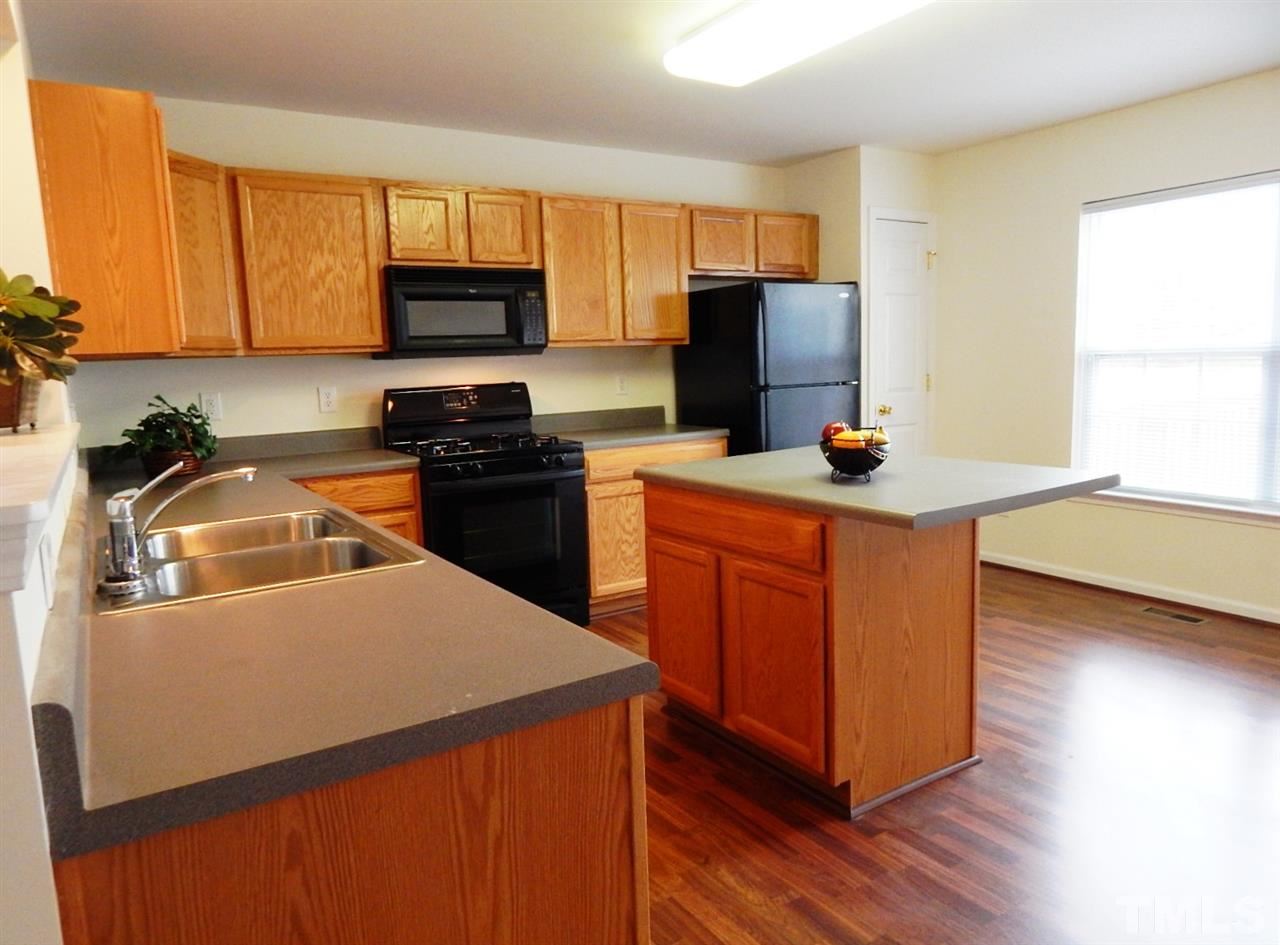 5051 Neuse Commons Lane Raleigh, NC 27616 - Photo 6 of 23 a kitchen with stainless steel appliances granite countertop a sink stove refrigerator and microwave