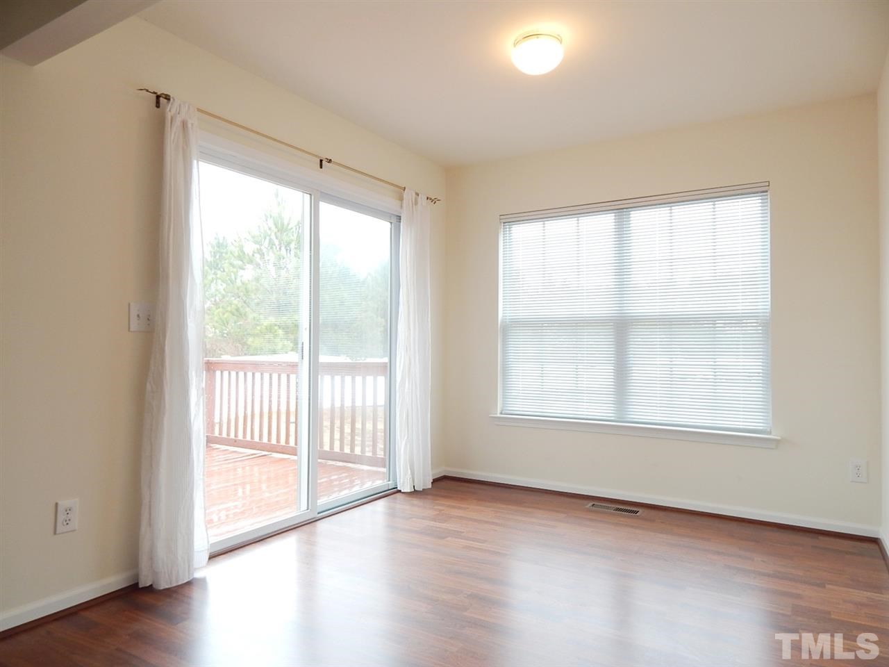 5051 Neuse Commons Lane Raleigh, NC 27616 - Photo 8 of 23 a view of an empty room with wooden floor and a window