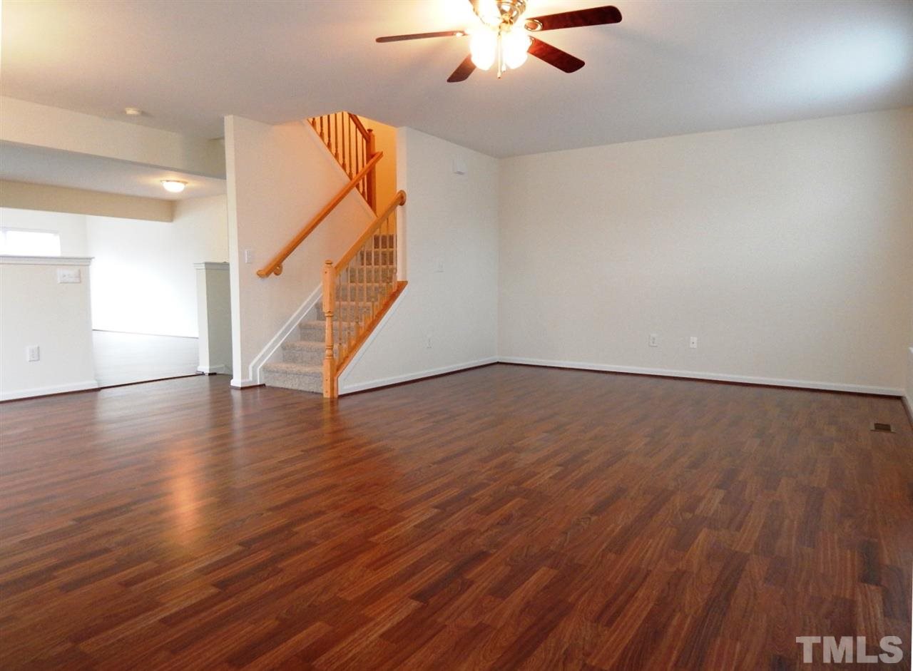 5051 Neuse Commons Lane Raleigh, NC 27616 - Photo 10 of 23 a view of an empty room with wooden floor and a ceiling fan