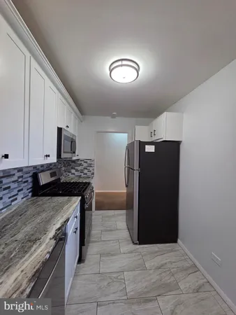 a kitchen with stainless steel appliances granite countertop a stove and a refrigerator