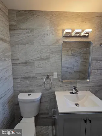 a bathroom with a toilet a sink and mirror