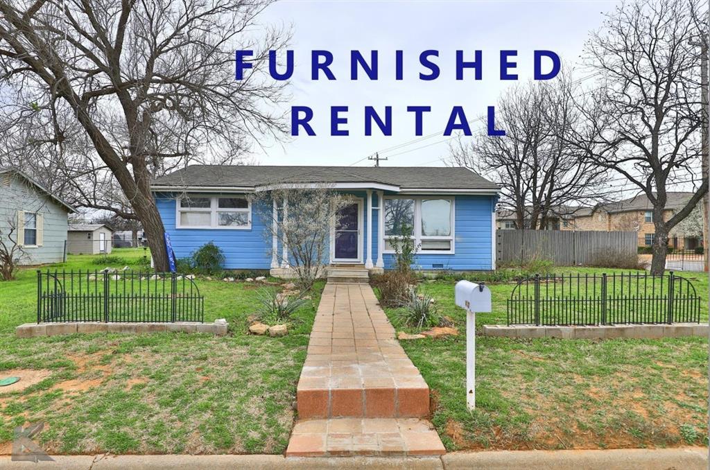 Bungalow featuring a shingled roof, a front lawn, and fence