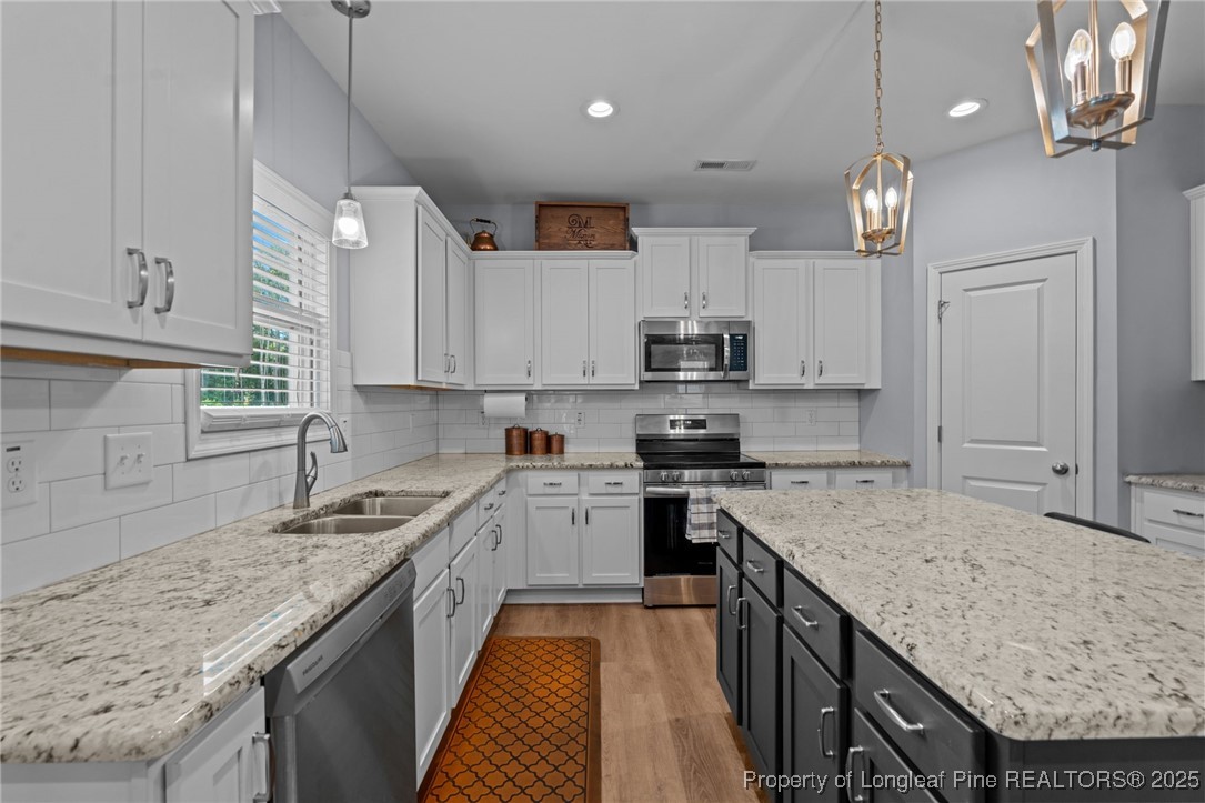 125 Solomon Drive Cameron, NC 28326 - Photo 11 of 49 a kitchen with granite countertop kitchen island a sink stove and cabinets