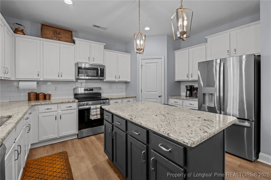125 Solomon Drive Cameron, NC 28326 - Photo 12 of 49 a kitchen with stainless steel appliances granite countertop a sink refrigerator stove and microwave