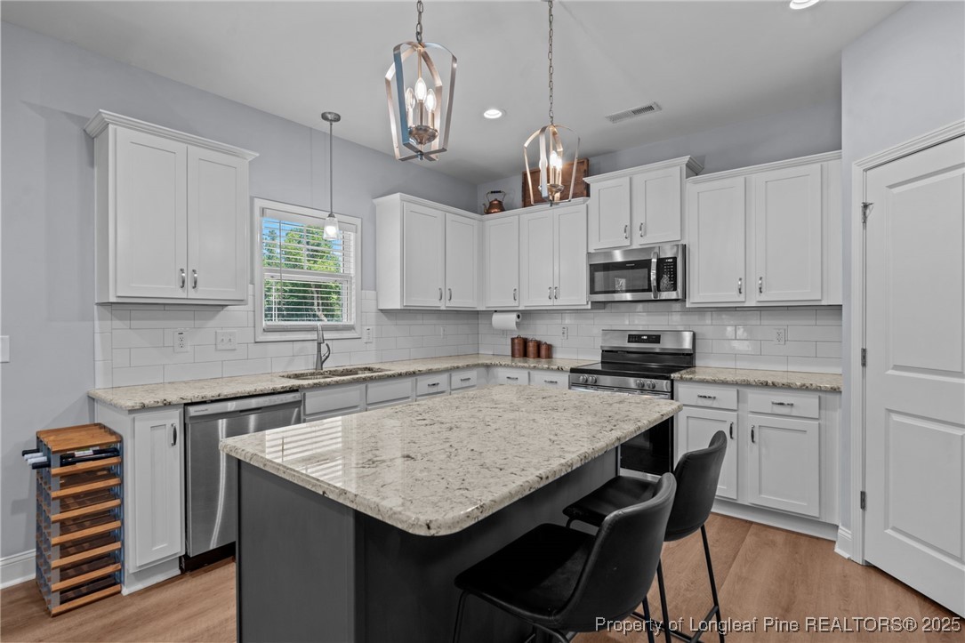125 Solomon Drive Cameron, NC 28326 - Photo 13 of 49 a kitchen with kitchen island granite countertop a sink a center island and cabinets