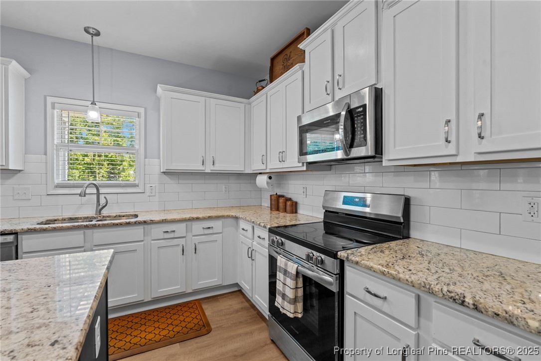 125 Solomon Drive Cameron, NC 28326 - Photo 15 of 49 a kitchen with stainless steel appliances granite countertop white cabinets granite counter tops and a window