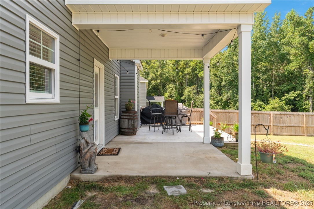 125 Solomon Drive Cameron, NC 28326 - Photo 30 of 49 a view of a patio with table and chairs potted plants and floor to ceiling window