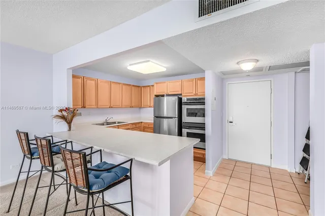 a kitchen with stainless steel appliances a table and chairs in it