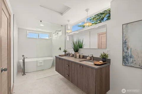 a bathroom with a double vanity sink mirror and bathtub