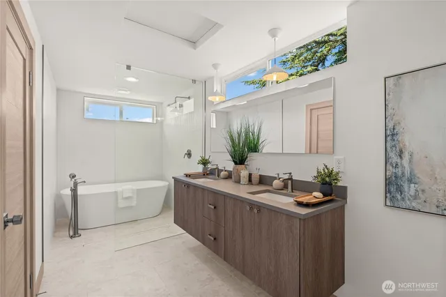 a bathroom with a double vanity sink mirror and bathtub