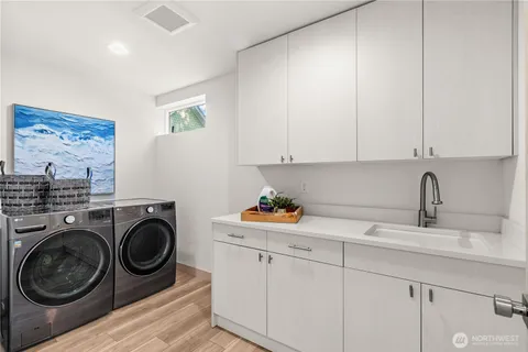 a view of a storage and utility room with sink dryer and washer