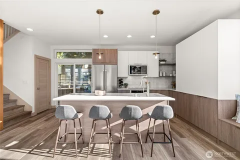 a kitchen with sink a microwave and chairs