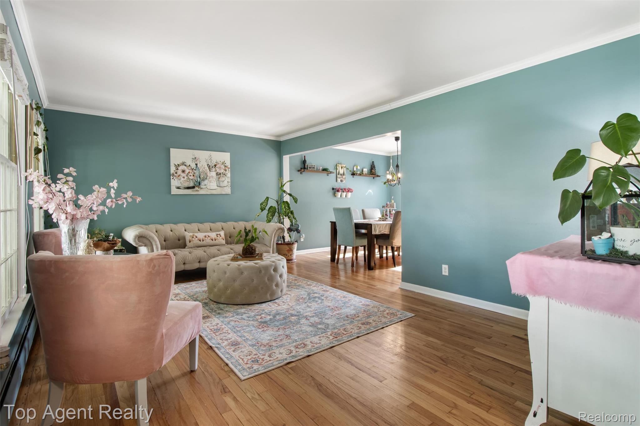 32341 Woody Road Fraser, MI 48026 - Photo 6 of 47 Bright living area featuring wood-finish flooring, light blue walls, white crown molding, and a wide entryway