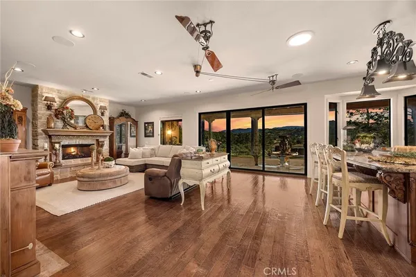 a kitchen with stainless steel appliances kitchen island granite countertop a table chairs sink and cabinets