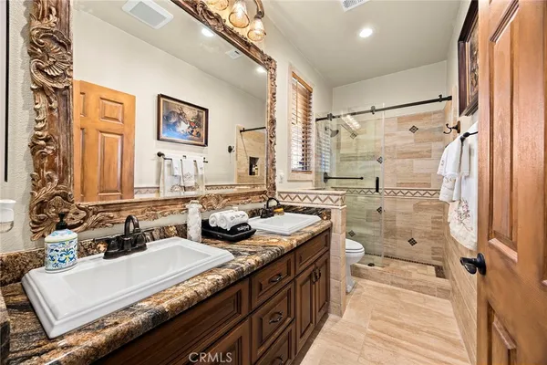 a view of a patio with table and chairs potted plants and floor to ceiling window