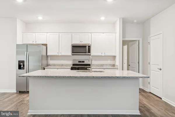 a kitchen with stainless steel appliances a refrigerator sink stove microwave and cabinets